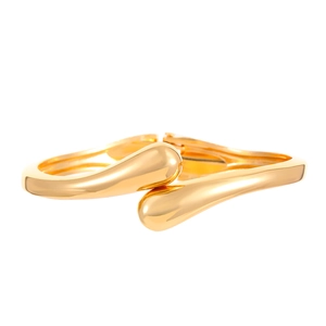 Macro detail of high-polished gold droplet bangle showing mirror finish and curved shape