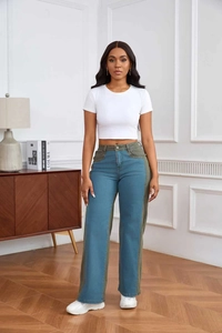 Détail du jean taille haute montrant le patchwork contrasté bleu et vert olive