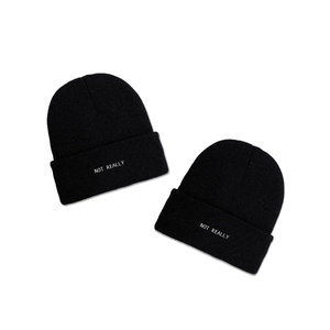 Two black knitted beanies with NOT REALLY white lettering on a clean white background
