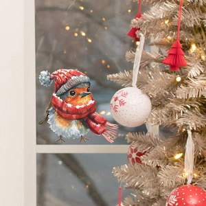 Détail d'un sticker de fenêtre oiseau de Noël avec bonnet rouge et écharpe sur verre