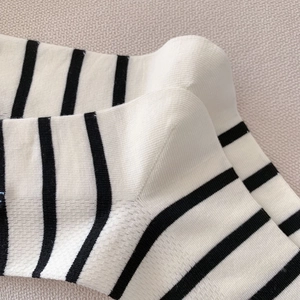 Gros plan détaillé sur la texture du tricot et les rayures noires et blanches des chaussettes