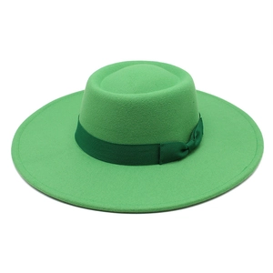 Détail d'un chapeau en laine vert vif avec un ruban décoratif et un nœud sur le bord