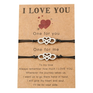 Handmade infinity heart charm bracelets for couples on a poetic message card display