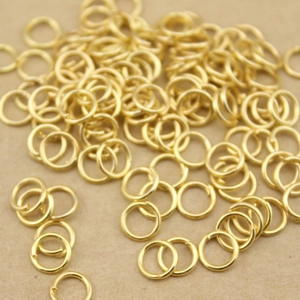 Close-up of golden metal jump rings for DIY jewelry making connections and crafts