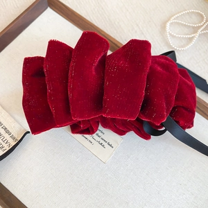 Détail macro d'un nœud papillon en velours rouge avec rubans et texture élégante