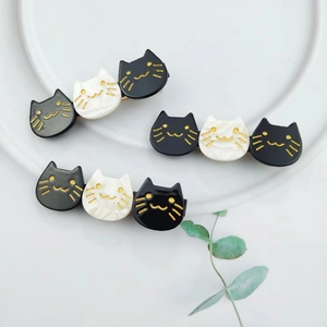 Close-up of cute black and white acetate cat hair clips with elegant gold detailing