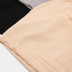 Macro detail of breathable slub texture knitted fabric in beige, black, and dark gray