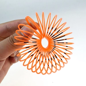 Detail of orange Halloween slinky toy with pumpkin face pattern being held in hand