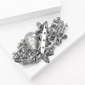 Detailed back view of silver alloy brooch showing secure safety pin and metal base