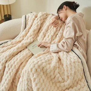Thick checkered fleece blanket in cream beige shown in a cozy home living room setting