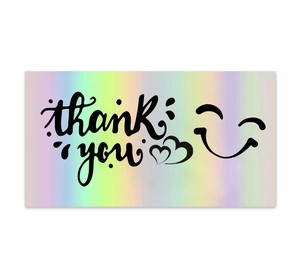 Close-up of holographic rainbow thank you card with black lettering and heart icon