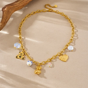 Golden chain necklace with 3D bears, heart pendant and pearls on a natural wood background