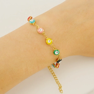Detail of 18K gold plated Evil Eye bracelet with colorful enamel charms on wrist