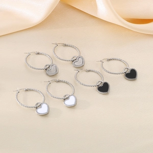 Détail de trois paires de créoles torsadées avec pendentifs en forme de cœur coloré