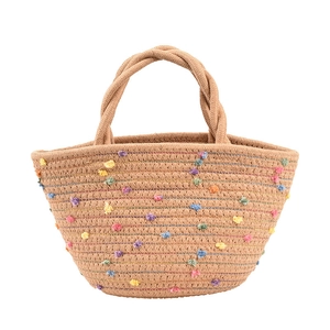 Handmade woven straw tote bag with colorful pom-poms and sturdy braided top handles