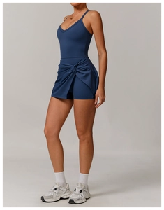 Detail of navy blue tennis dress featuring crisscross cutout back and wrap knot skirt design
