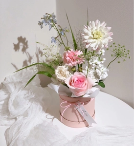 Pink floral arrangement in a round mini hug bucket with roses and elegant gift tag