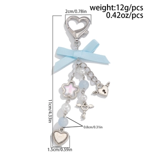 Detailed view of light blue bow keychain with size annotations and charms on white background