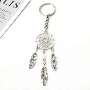 Détail d'un porte-clés attrape-rêves en alliage argenté avec perle rose et trois plumes