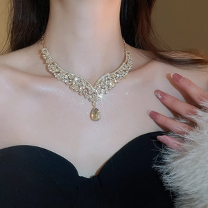 Detailed view of luxury V-shaped rhinestone drop necklace worn on model neck