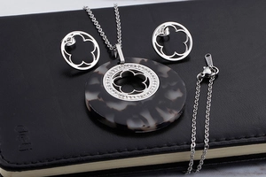 Detail of stainless steel floral necklace and earrings with tortoiseshell resin inlays
