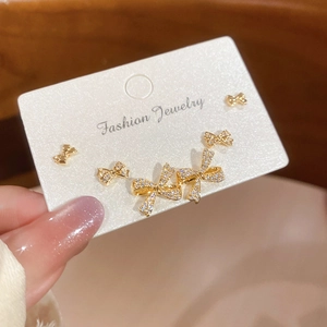 Close-up of three pairs of 18k gold plated bow knot earrings with sparkling zircon stones