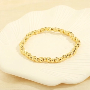 Detailed shot of gold beaded bracelet with alternating polished and textured beads