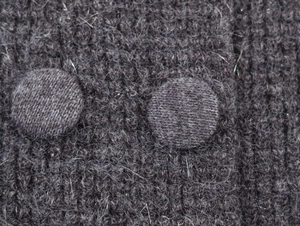 Detailed macro view of dark grey fuzzy knit fabric featuring dual fabric-covered buttons