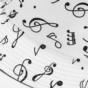 Close-up of white bucket hat featuring musical notes pattern and durable stitched brim