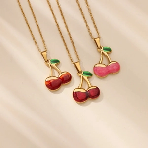 Three elegant cherry pendant necklaces in orange, dark red, and pink with gold chains
