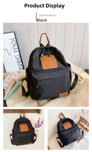 Close-up of black canvas backpack with brown leather smile patch and side pockets