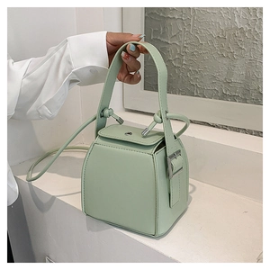 Close-up of a stylish mint green PU leather box bag with silver buckle and handle