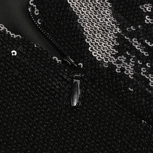 Detail of sequin fabric with silver stripes and black zipper on backless dress
