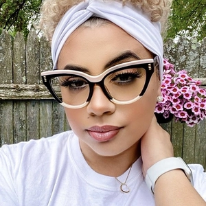 Cat eye glasses frames with two-tone black and pink design and metal studs on a model