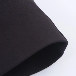 Détail macro de la texture en maille noire fine et de la structure de l'ourlet doublé