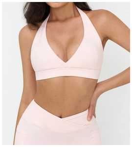 Dettaglio del set yoga rosa chiaro con reggiseno sportivo a V e leggings a V