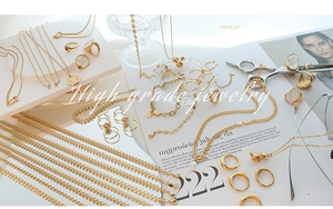 Flat lay of gold titanium steel jewelry collection with heart necklace and rings