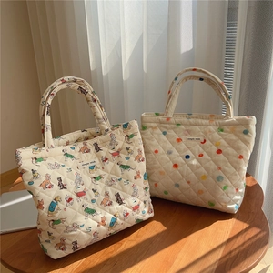 Detailed view of quilted cotton tote bags with cute dog patterns and polka dot textures