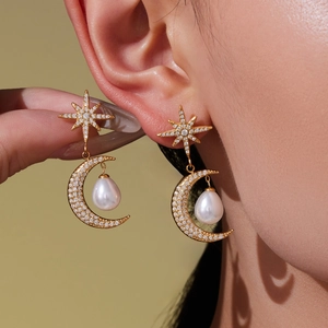 Élégantes boucles d'oreilles lune et étoile dorées avec zircons sur un mannequin