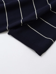 Close-up of ribbed cuffs and fine navy blue knit fabric with white horizontal stripes