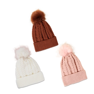 Three cable knit beanie hats in white, brown, and pink with large fluffy pom-poms