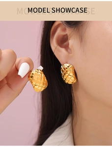 Detail shot of vintage geometric quilted pattern on gold plated titanium earrings