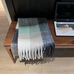 Detailed view of thick tassels on a rainbow plaid cashmere-feel winter scarf