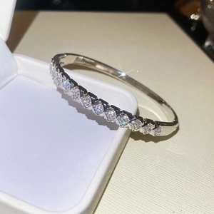 Detailed view of silver luxury bangle with pavé-set stones on a jewelry box display