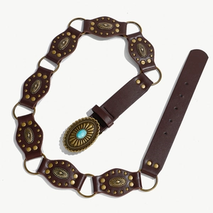 Dettaglio di cintura boho con anelli in bronzo e fibbia decorata con pietra turchese