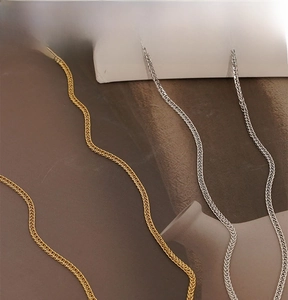 Détail de la texture tressée de la chaîne Chopin en acier inoxydable doré et argenté