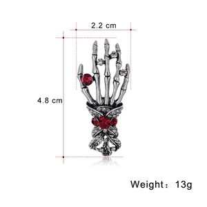 Retro punk skeleton hand brooch with red and white rhinestones in silver finish