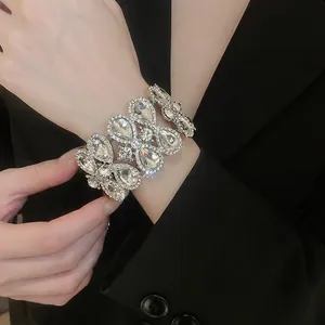 Luxury geometric silver bracelet with layered pear-cut rhinestones worn on black suit