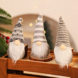 Detailed close-up of three knitted Christmas gnomes with striped patterns in a wooden crate