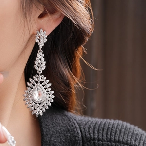 Close-up of silver teardrop earrings with crystals and pearls on model for elegant look